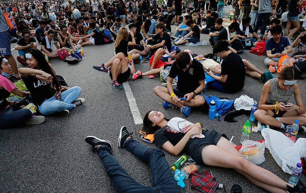Pro-democracy protesters take afternoon naps on the streets in Hong Kong.