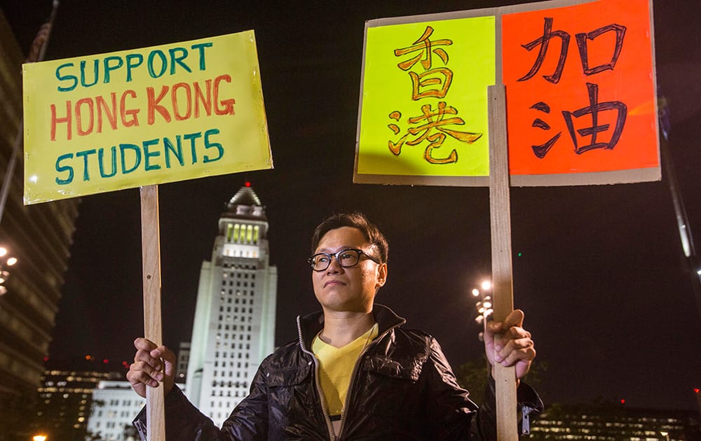 Donald Choy, member of Hong Kong Forum, Los Angeles, holds signs joins hundreds of demonstrators at Grand Park downtown Los Angeles to show his support for the pro-democracy protesters in Hong Kong that have been dubbed the 'umbrella revolution', in Los Angeles. 