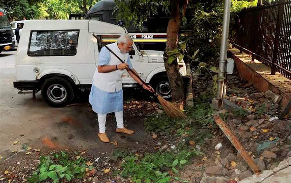 Prime Minister Narendra Modi wields the broom during a surprise visit to the Mandir Marg Police Station after launch of Swachh Bharat Abhiyan in New Delhi.