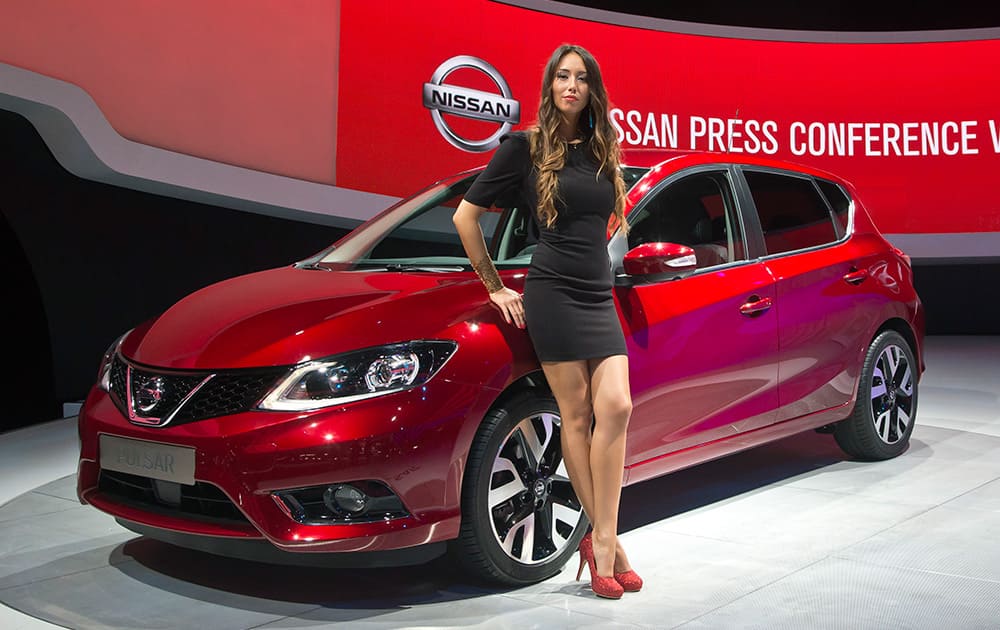 A hostess poses next to a Mazda Pulsar car during the press day at the Motor Show in Paris. European carmakers are hoping to impress with new models at this week's Paris Motor Show and prove they have come out stronger from years of economic trouble and cost-cutting.