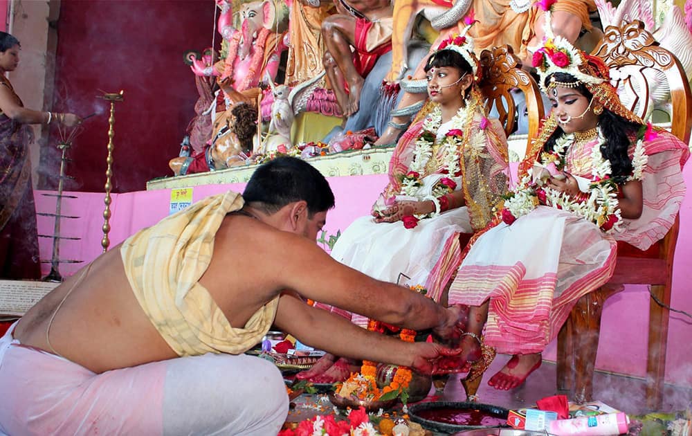 A priest performs rituals to young girls dressed as the Hindu goddess Durga during the Maha Ashtami celebrations at Balurghat in Dinajpur.