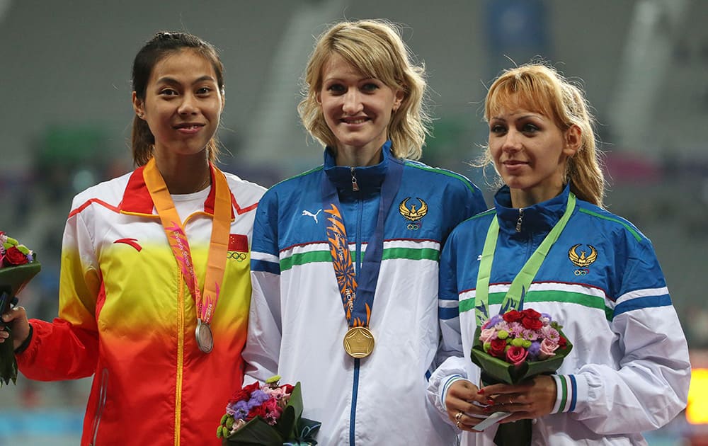 Uzbekistan's Svetlana Radzivil who won the gold poses with China's Zheng Xingjuan, left who won the silver and compatriot Nadiya Dusanova, right, who won the bronze during the medal ceremony of the women's high jump event at the 17th Asian Games in Incheon, South Korea