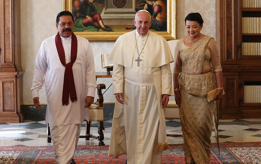 Pope Francis poses for photographers with Sri Lankan president Mahinda Rajapaksa, left, and his wife Shiranthi on the occasion of their private audience, at the Vatican.