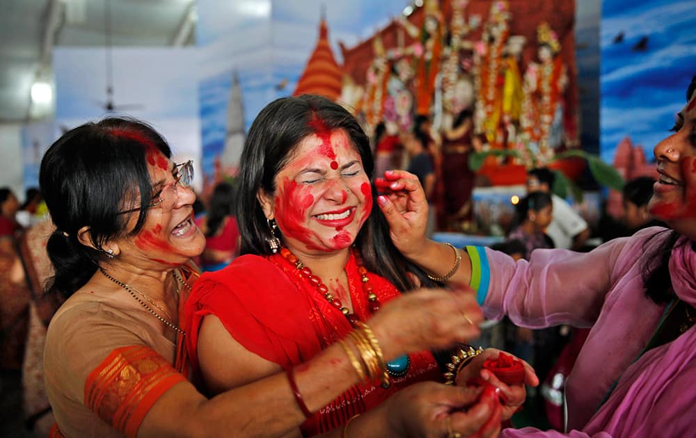 Indian Hindu women apply vermillion on each other during Durga Puja festivities in Allahabad.