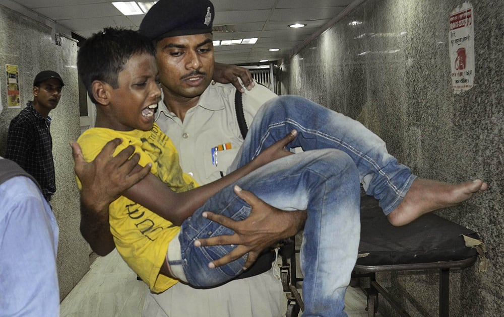 An Indian policeman carries a boy injured in a stampede in Patna.