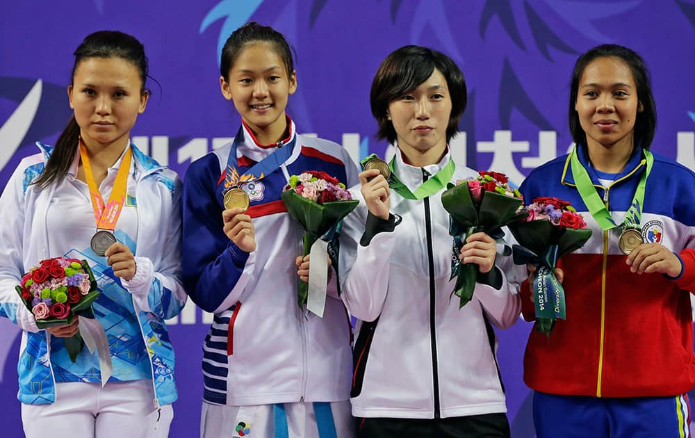 Silver medallist Kazakhstan’s Sabina Zakharova, gold medallist Taiwan’s Wen Tzu Yun and bronze medallists Japan's Miki Kobayashi and Philippines's Mae Soriano display their medals for the women’s -55kg karate at the 17th Asian Games in Incheon, South Korea.