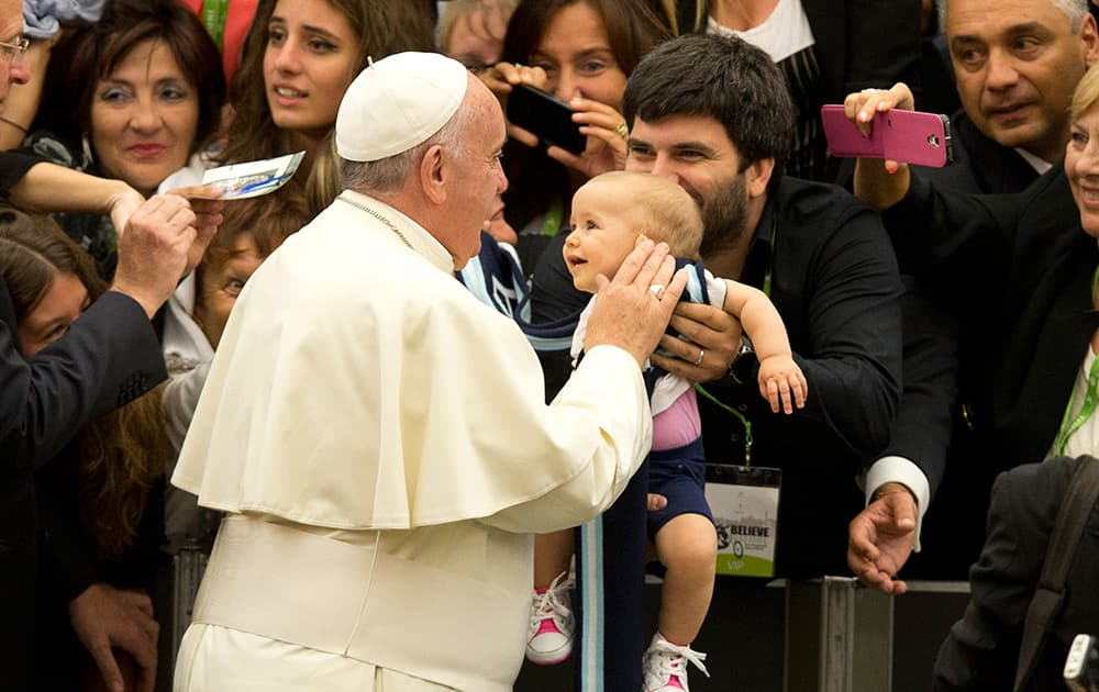 Pope Francis caresses a child as he arrives in the Paul VI hall on the occasion of the pontiff's meeting with paralympic athletes, part of the 'Believe to Be Alive' paralympic gala which will be held in Rome, at the Vatican City.