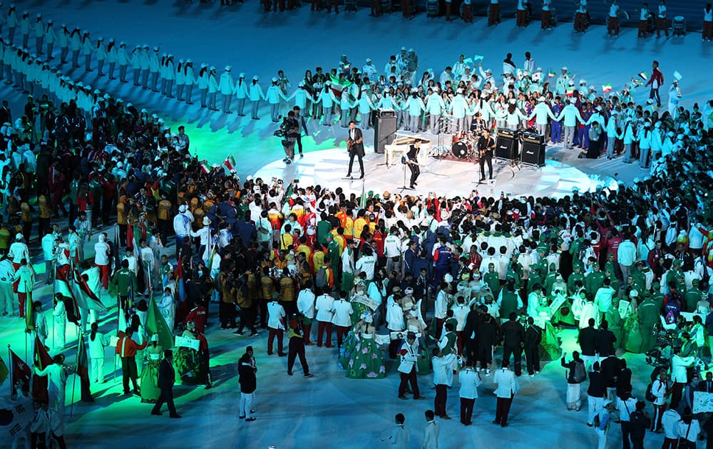 Athletes listen to a band perform during the closing ceremony of the 17th Asian Games in Incheon.