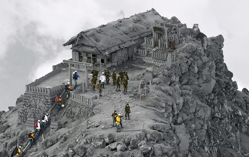 Japan Ground Self-Defense Force personnel and other rescuers arrive to conduct search operations at the ash-covered Ontake Shrine near the summit of Mount Ontake in central Japan.