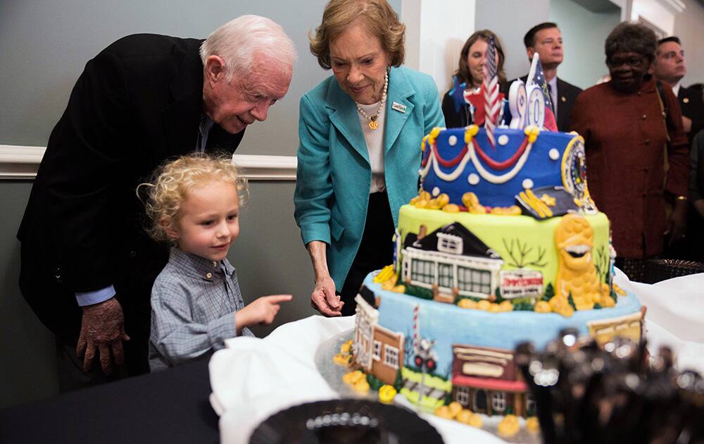 Former President Jimmy Carter, grandson Errol, 4, and former first lady Rosalynn Carter look at a birthday cake during Jimmy Carter's 90th birthday celebration held at Georgia Southwestern University in Americus, Ga.