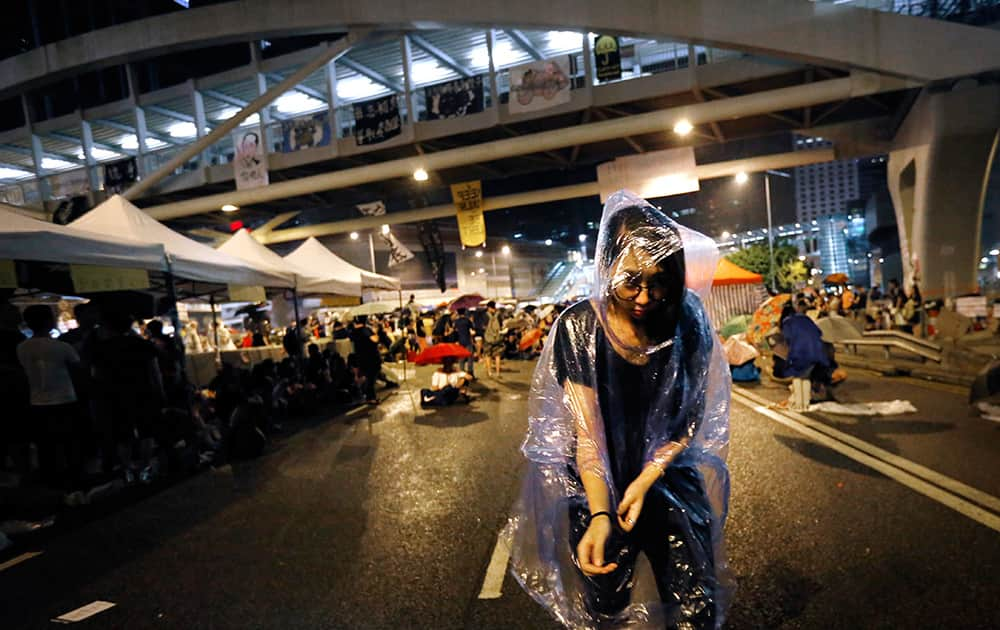 A student pro-democracy protester moves to shelter as it starts raining near government headquarters where they have been camping overnight in Hong Kong.