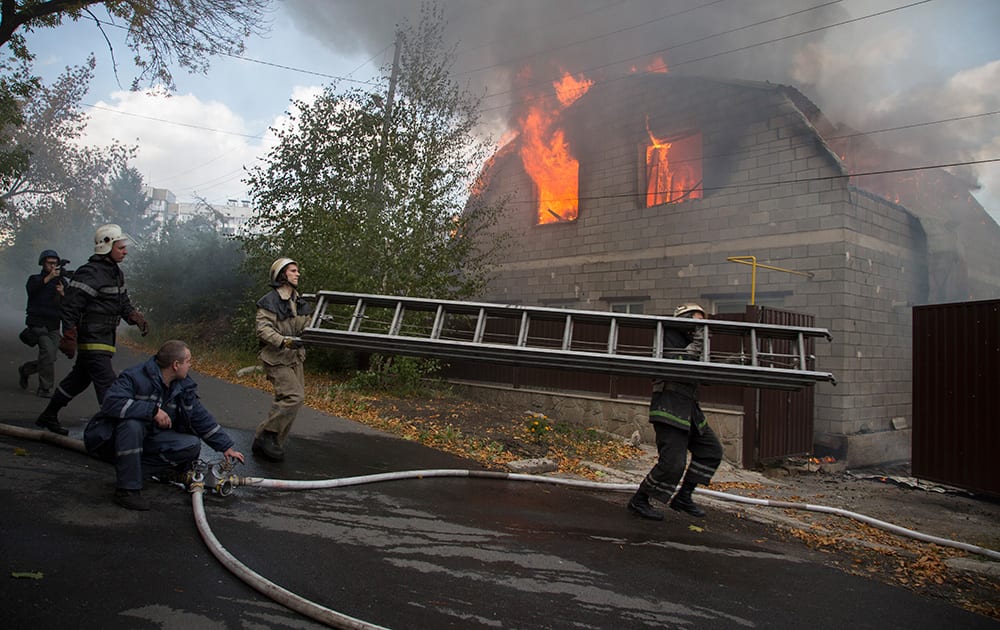 Firefighters try to extinguish a burning private house after shelling in the town of Donetsk, eastern Ukraine.