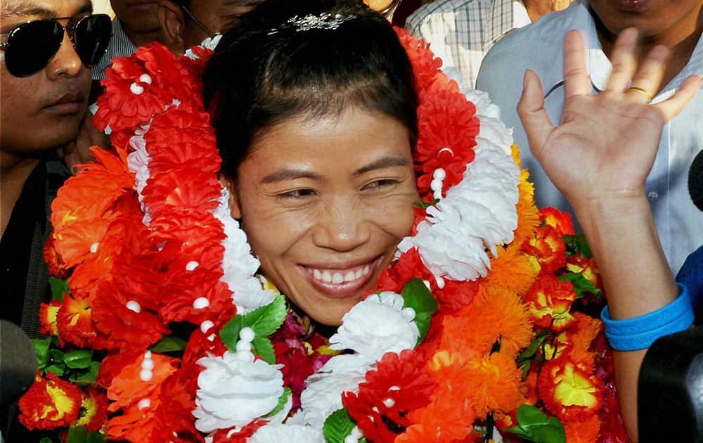 Asian Games gold medalist boxer Mary Kom is greeted with garlands upon her arrival at the International Airport in Imphal.