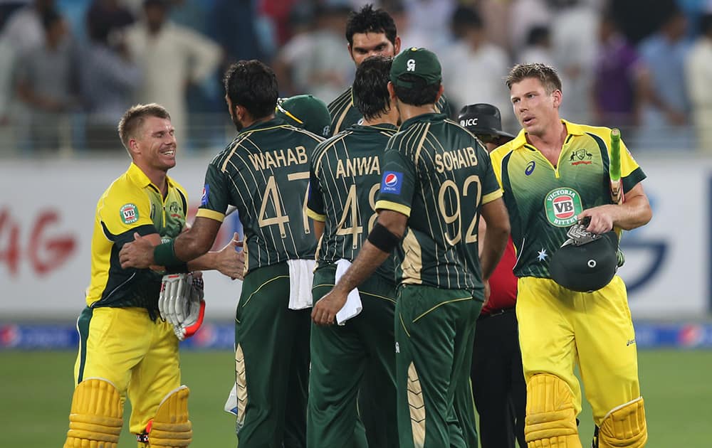 Australian batsmen David Warner and James Faulkner shake hands with Pakistani players after beating Pakistan during the International T20 match by six wickets in Dubai, United Arab Emirates.