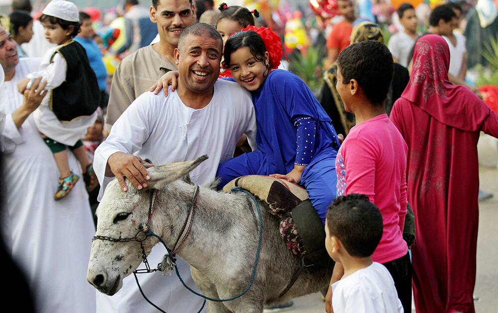 Egyptians celebrate after the early morning prayers marking Eid al-Adha, a three-day Muslim holiday that started Saturday across much of the Middle East, in Cairo, Egypt.