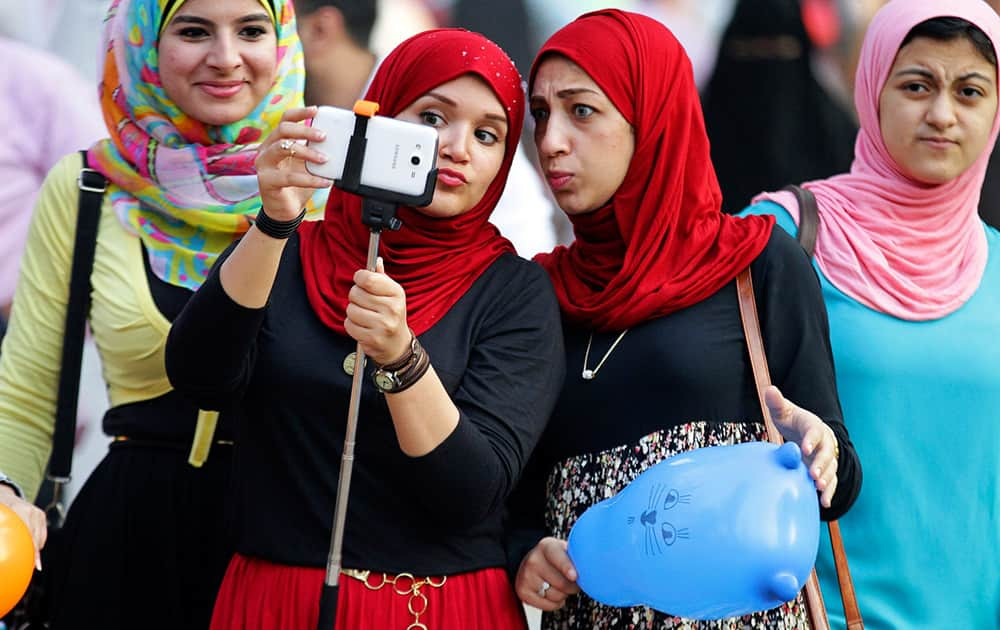 Egyptians take a photo following the early morning prayers marking Eid al-Adha, a three-day Muslim holiday that started Saturday across much of the Middle East, in Cairo, Egypt.