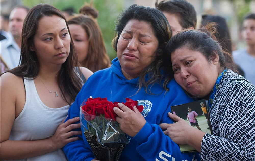 Prady Aguilar, whose son Matthew, 15, died in a car crash is consoled during a candlelight vigil at Capistrano Valley High School in Mission Viejo, Calif.