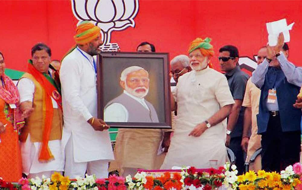 Prime Minister Narendra Modi is presented with his portrait at an election rally in Hisar.