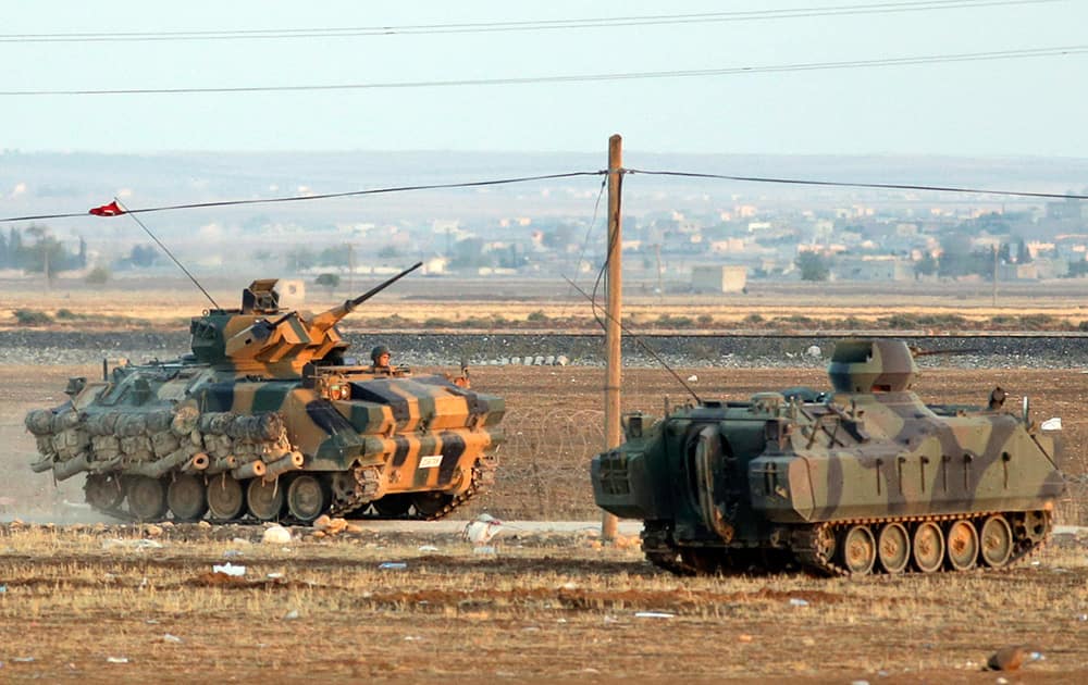 Turkish forces on armoured vehicles at the outskirts of Suruc, secure the border area with Syria, background. Kobani, also known as Ayn Arab and its surrounding areas have been under attack since mid-September, with militants capturing dozens of nearby Kurdish villages.