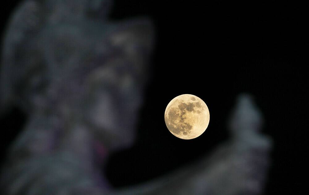 An unusually brilliant moon rises over Mexico City's Independence Monument.