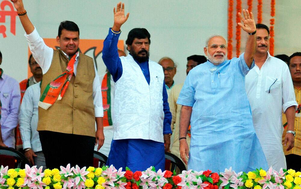 Prime Minister Narendra Modi waves along with RPI chief Ramdas Athavale and Maharashtra BJP chief Devendra Phadnavis at an election campaign rally at Kasturchand Park in Nagpur, Maharashtra.