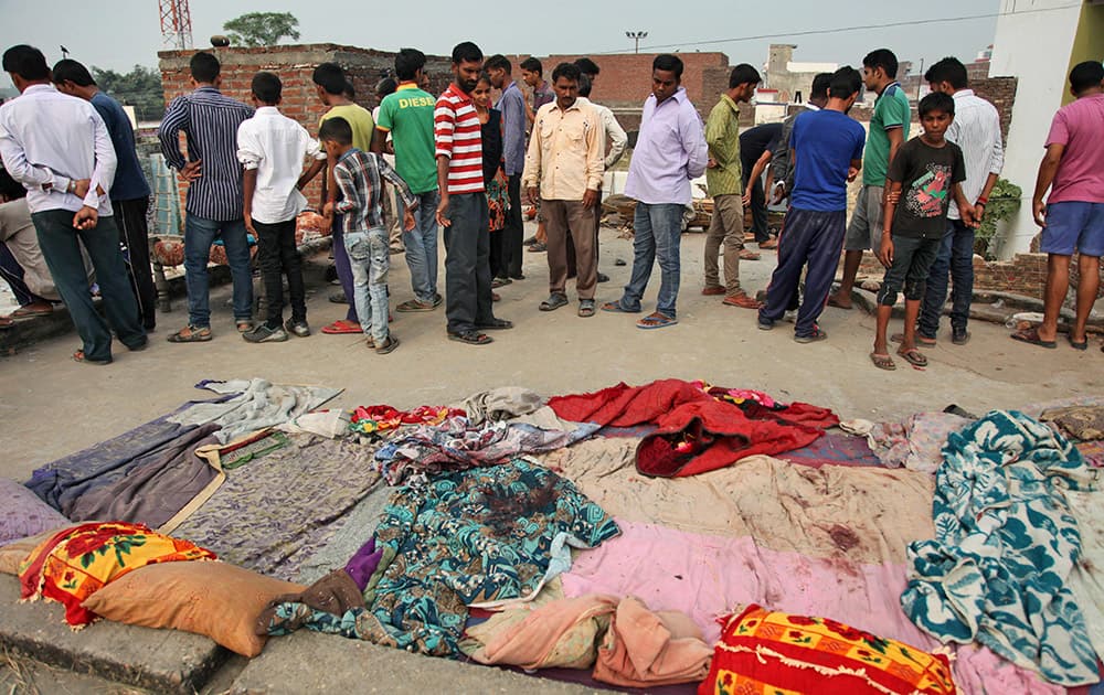 Indian villagers gather near bed sheets stained with blood in alleged firing from the Pakistan’s side while the residents were asleep on roof of their house, at Masha da kothe village, in Arnia Sector near the India-Pakistan international border.