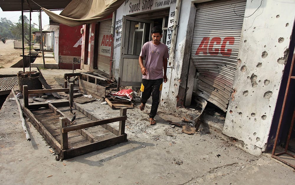 An Indian villager walks near damaged shops hit by mortar attack allegedly fired from the Pakistan’s side in Arnia Sector near the India-Pakistan international border.