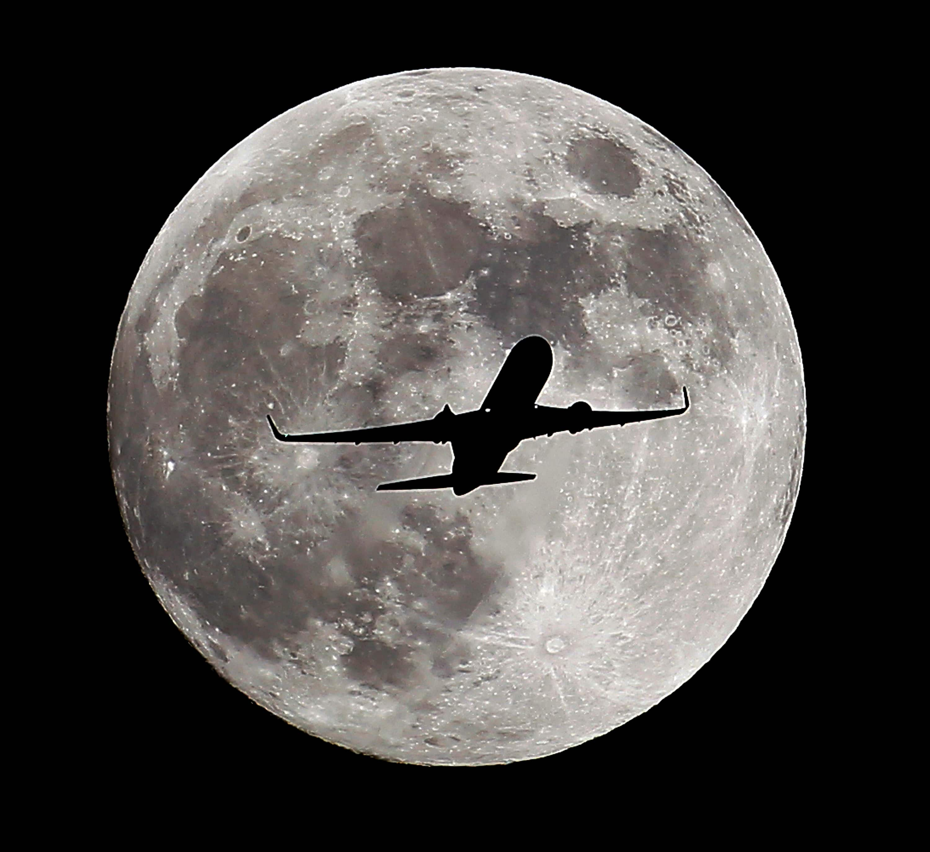 A passenger airliner crosses the full moon, also known as the Hunter's Moon, a few hours prior to the beginning of a total lunar eclipse that will create an effect known as the Blood Moon, in Whittier, Ca.