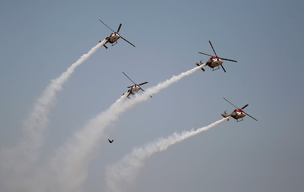 An eagle flies close to the Indian Air Force (IAF) Sarang helicopters as they perform a display during Air Force Day at the air force station in Hindon near New Delhi.