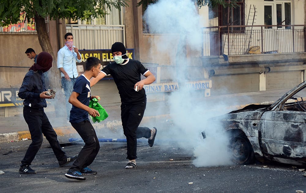 Protesters demonstrating against Turkey's policy in Syria run as Turkish riot police use water cannons and tear gas in Diyarbakir, Turkey.