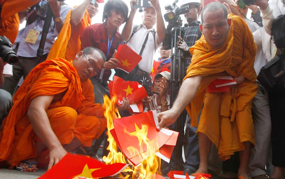 Cambodian protesters burn mock Vietnamese flags during a protest at a blocked main street in front of Vietnamese Embassy in Phnom Penh, Cambodia.