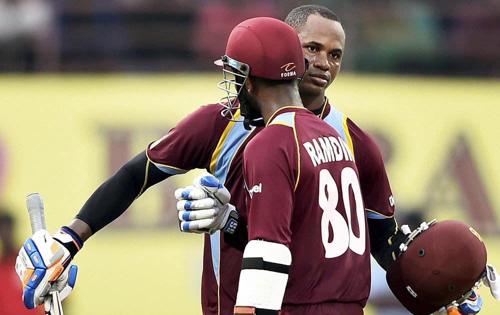 West Indies cricketer Marlon Samuels celebrating his century along with teammate D Ramdin during the first ODI match against India at Jawaharlal Nehru Stadium in Kochi.