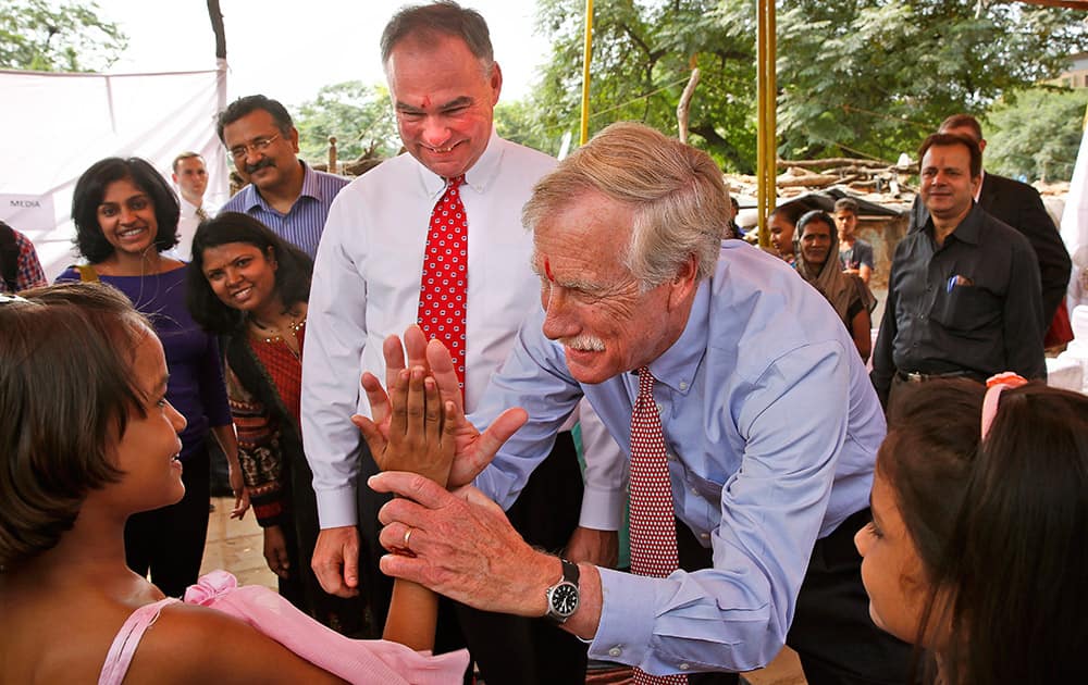 U.S. Sen. Angus King, I-Maine, right, teaches high-five to an Indian girl next to Sen. Tim Kaine, D-Va, during their visit to Sanjay Gandhi J.J. Cluster shanty town to overview sanitation programs run by non-governmental organizations, in New Delhi, India.