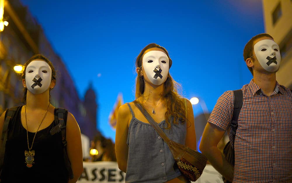 Students wearing white masks and a black cross covering the mouth protest against a decision by Spain’s Constitutional Court which found that a vote for a referendum in Catalonia would be unconstitutional in Barcelona, Spain.