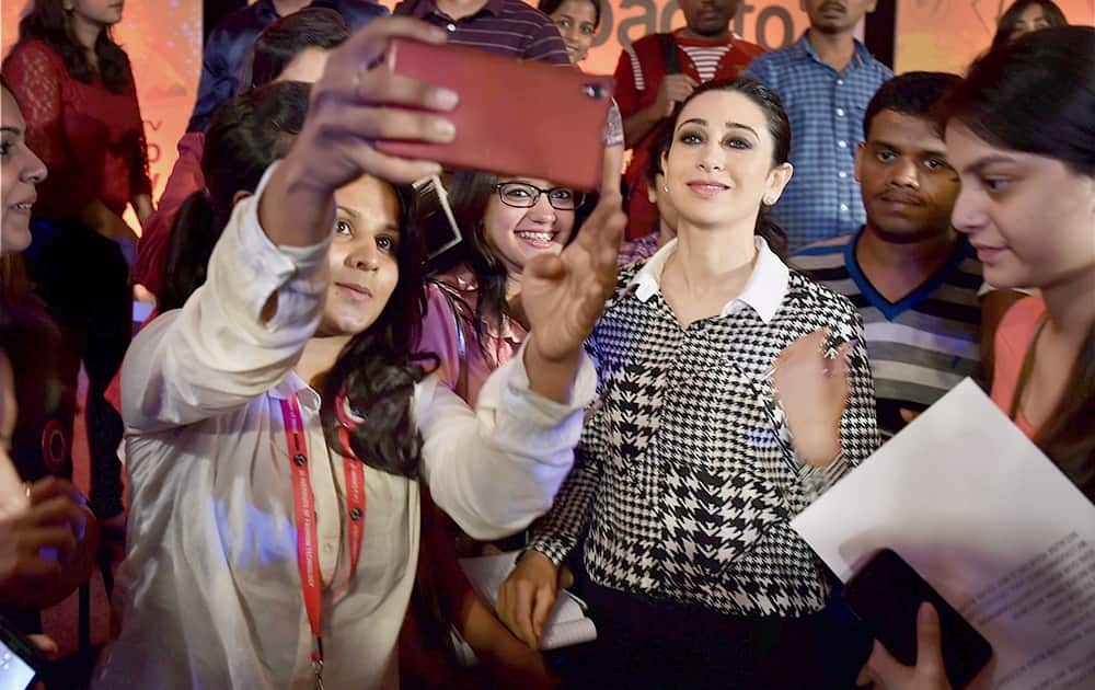 Girls taking a selfie with bollywood actress Karishma Kapoor during a road safety awareness campaign.