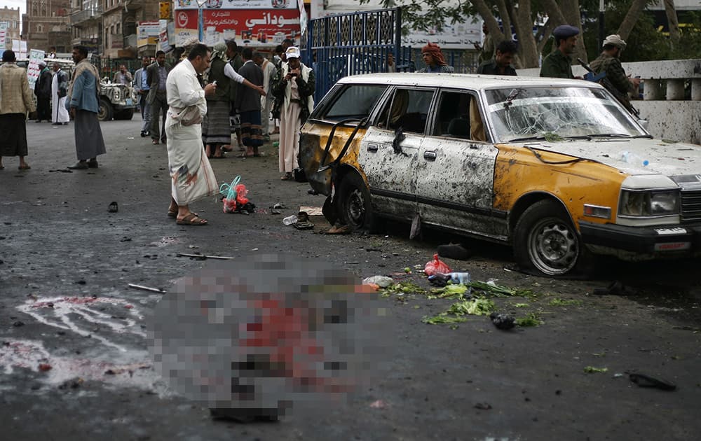 People gather at the site of a suicide bombing in Sanaa, Yemen.