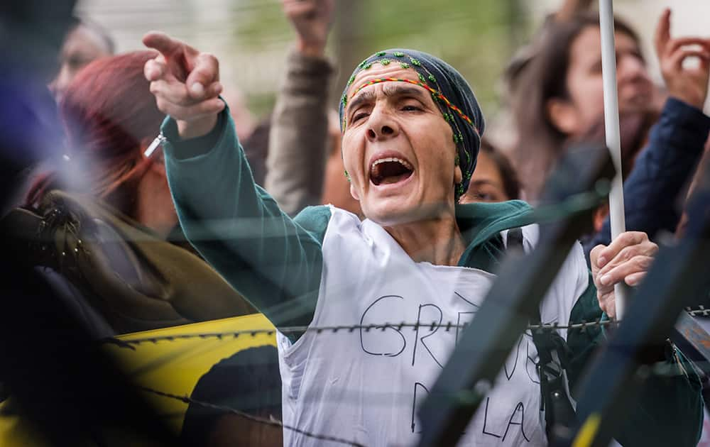 A Kurdish woman living in Belgium shouts slogans as she is on a hunger strike together with other Kurds to protest against the Islamic State militant attacks on the Syrian city of Kobani, in front of the Turkish embassy in Brussels.