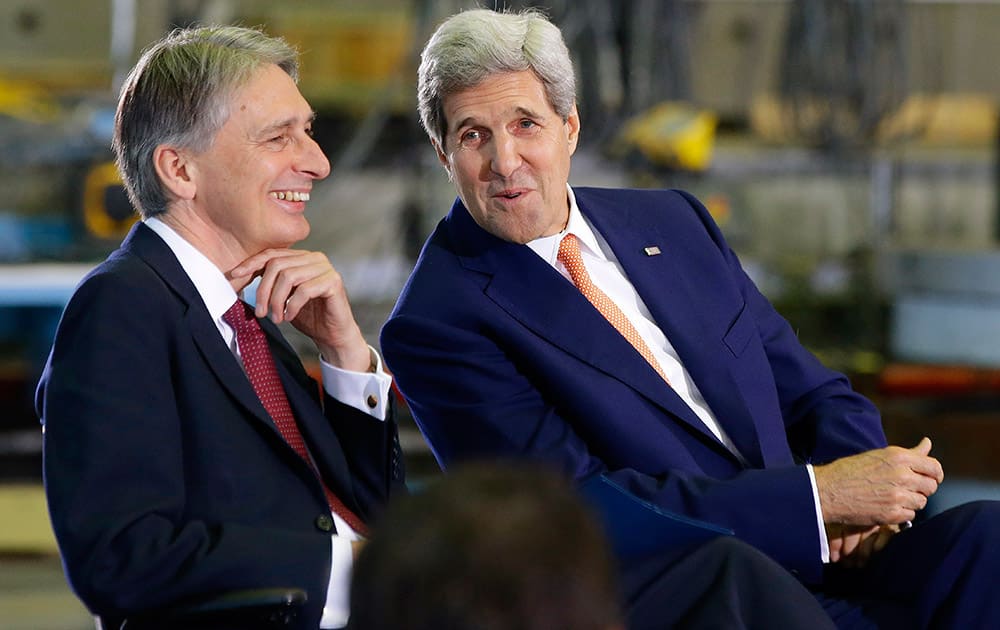 Secretary of State John Kerry, right, talks with British Foreign Secretary Philip Hammond before they spoke at the Wind Technology Testing Center, in Boston.