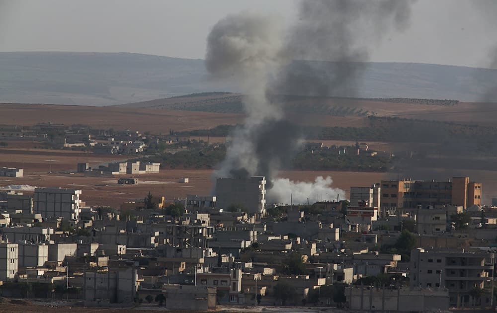 Smoke rises following an airstrike by US-led coalition aircraft in Kobani, Syria, during fighting between Syrian Kurds and the militants of Islamic State group.