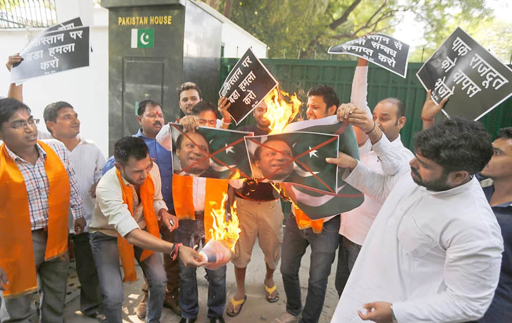A small group of activists of the Hindu Sena or the Hindu Army burn posters with the flag and portrait of Pakistan Prime Minister Nawaz Sharif outside the residence of Pakistan High Commissioner to India in New Delhi.
