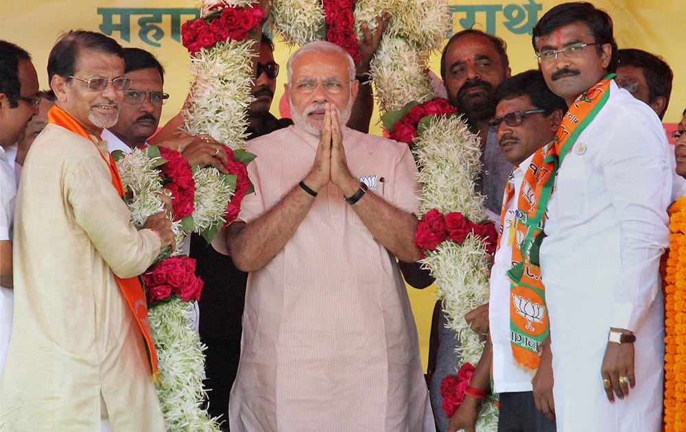 Prime Minister Narendra Modi being garlanded by party members at an election rally at Bramhapuri in Chandrapur district.