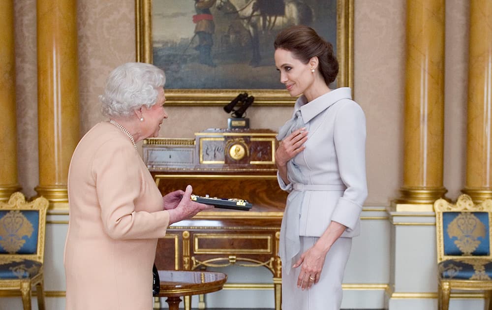 US actress Angelina Jolie is presented with the Insignia of an Honorary Dame Grand Cross of the Most Distinguished Order of St Michael and St George by Britain's Queen Elizabeth II at Buckingham Palace, London.
