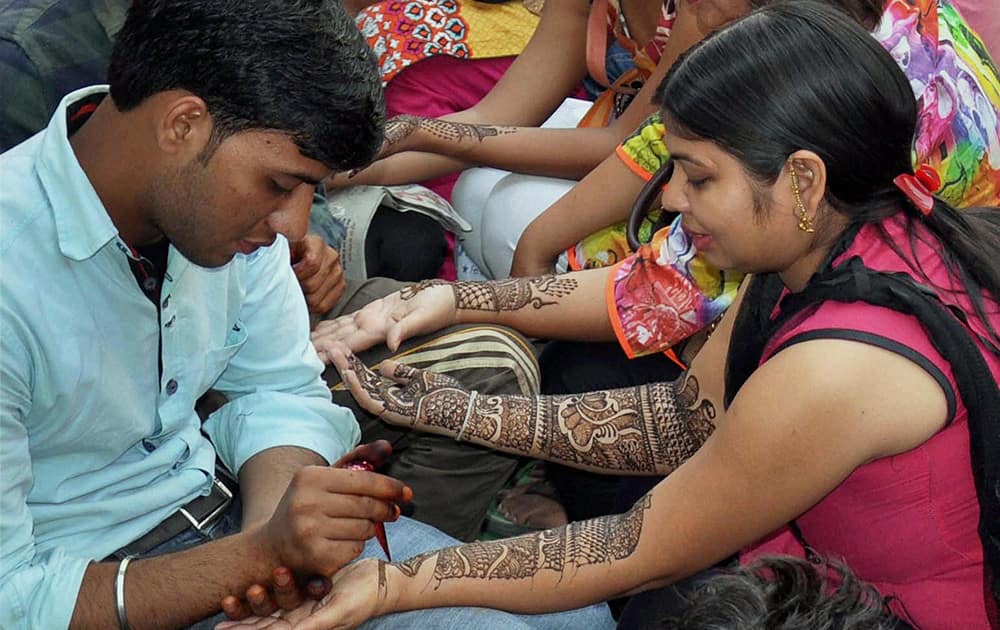 Women get their palms and arms decorated with mehandi on the eve of Karwa Chauth in Gurgaon.
