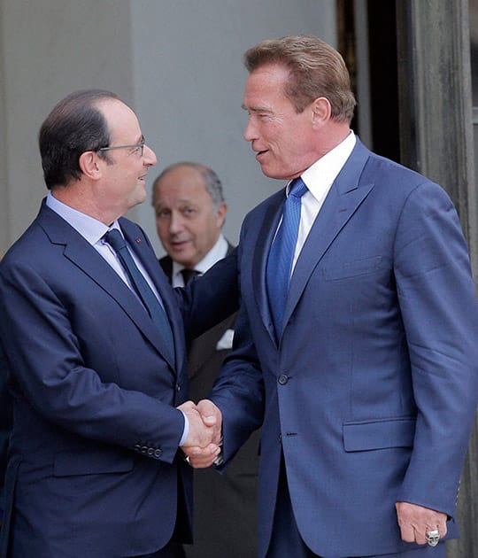 Former Governor of California and founding chair of the R20 initiative, Arnold Schwarzenegger, right, shakes hands with French President Francois Hollande after a meeting at the Elysee Palace in Paris.