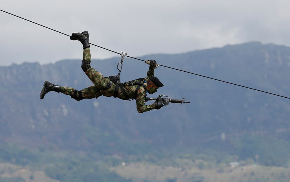 A Colombian Army Special Forces soldier ziplines during a show of military exercises at the Tolemaida military base during a visit by U.S. Defense Secretary Chuck Hagel, in Melgar, Colombia.