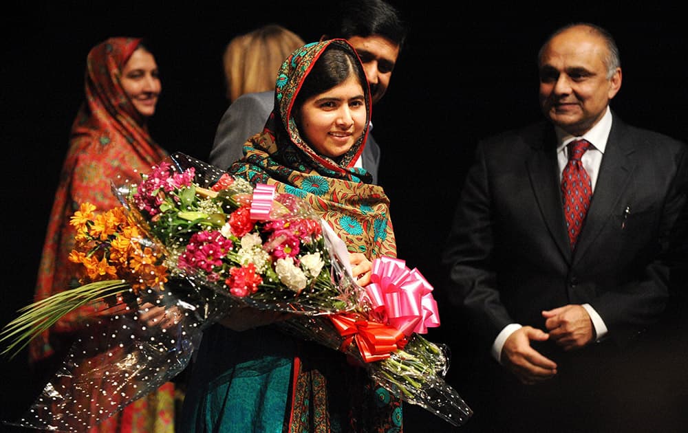 Malala Yousafzai holds flowers after speaking during a media conference at the Library of Birmingham after she was named as winner of The Nobel Peace Prize.