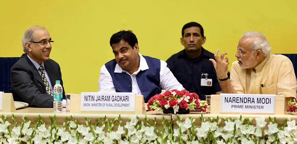 Prime Minister Narendra Modi talking to his Pricipal Secretary Nripendra Misra as Union Minister for Rural Development Nitin Gadkari looks on during the launch of Saansad Adarsh Gram Yojana (SAGY) in New Delhi.