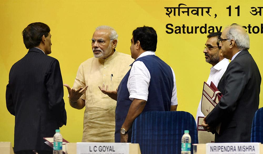 PM Narendra Modi talking to an official as Union Minister for Rural Development Nitin Gadkari and MoS Upendra Kushwaha look on during the launch of SAGY.