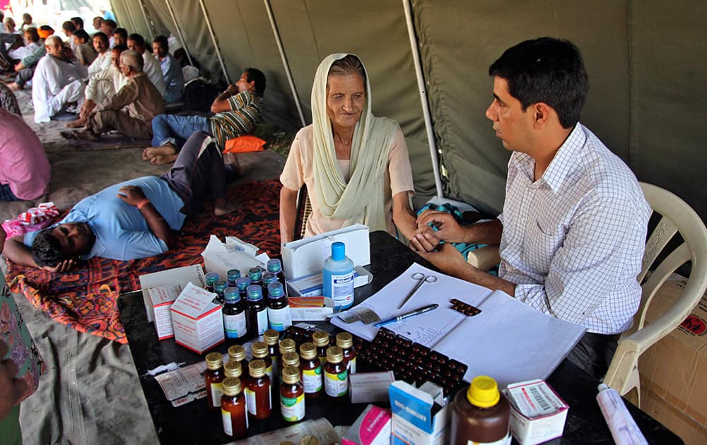 A doctor checks a border migrant woman, who fled from her home during exchange of firing between India and Pakistan, at an army relief camp at Deoli village, in Arnia sector, 40 kilometers (25 miles) from Jammu.