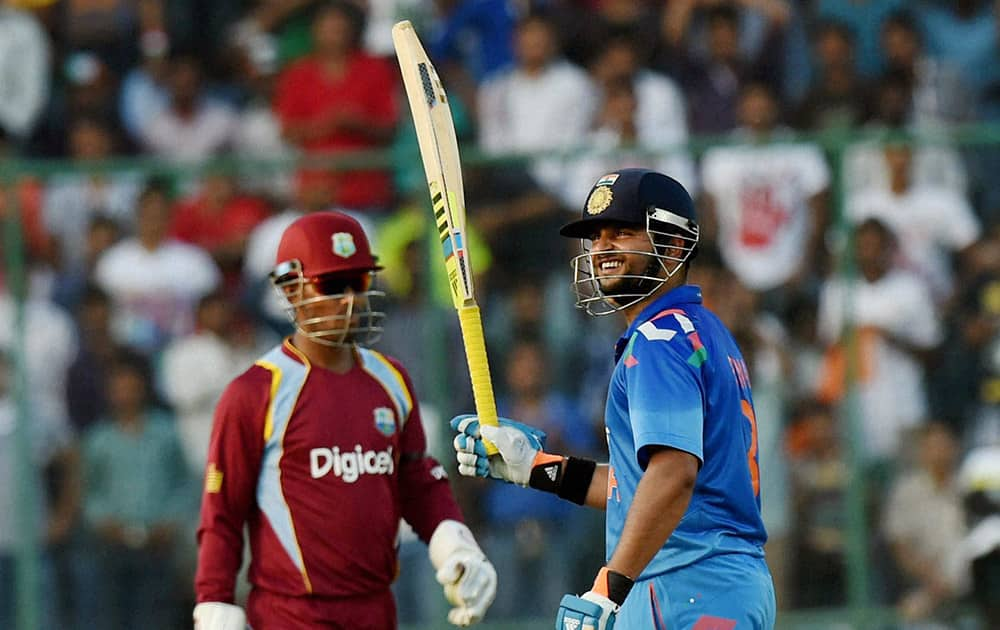 Suresh Raina celebrates his half century against West Indies during the 2nd ODI cricket match in New Delhi.